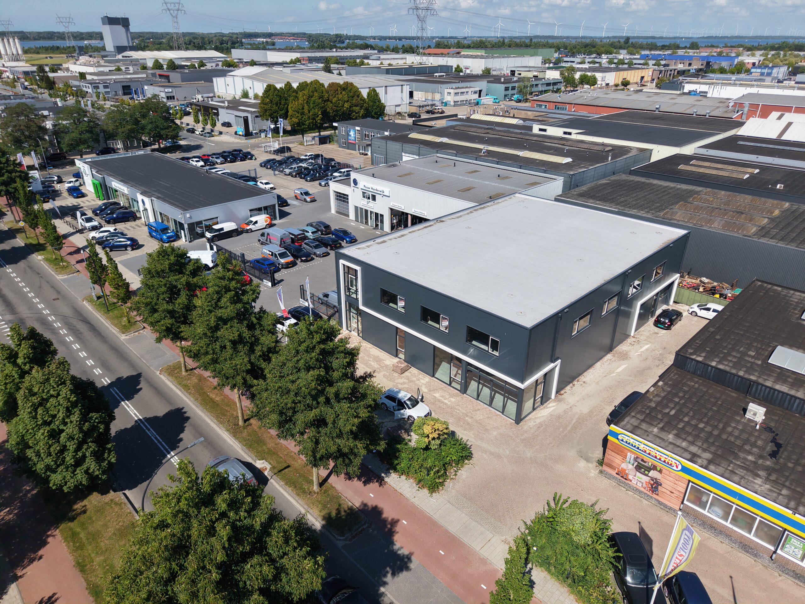 Een afbeelding van een bedrijfspand dat te huur wordt aangeboden in Harderwijk. Ontwikkeld voor ondernemers die op zoek zijn naar een plek waar zij kunnen groeien. De gevel is donkergrijs en het pand is casco opgeleverd.