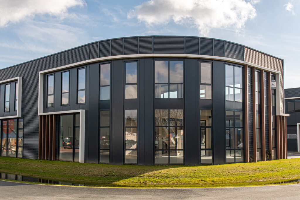 Modern hoekgelegen bedrijfspand in Dieren met grote glazen gevels, twee bouwlagen en representatieve uitstraling, gelegen op bedrijventerrein De Marke en geschikt voor ondernemers die een strategisch gelegen bedrijfspand nabij Arnhem zoeken.