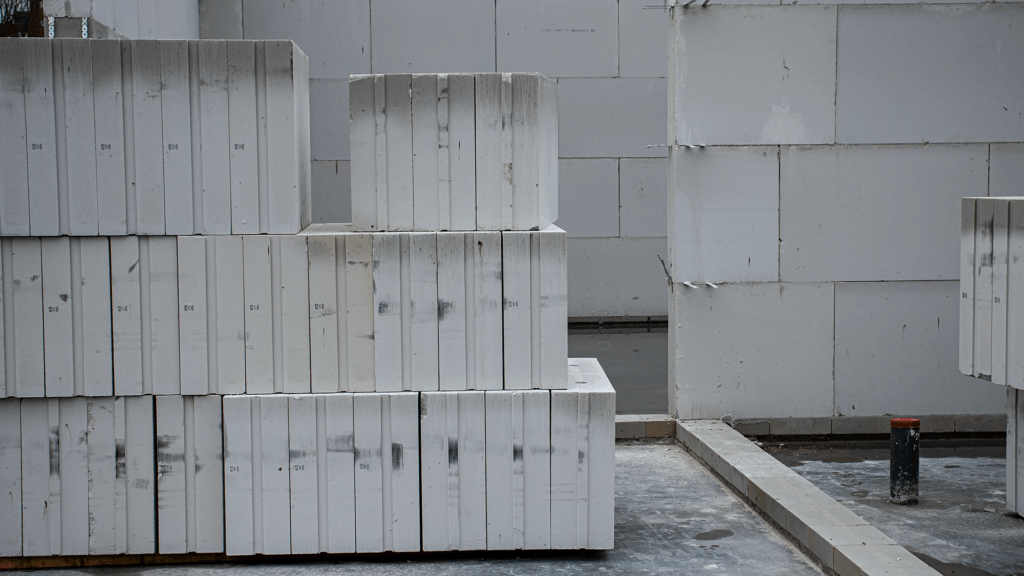 Stapels witte kalkzandsteenblokken op de bouwplaats van het bedrijfspand in Arnhem aan de Overmaat, zichtbaar geplaatst op de begane grondvloer als onderdeel van de opbouw van de binnenmuren van het pand in aanbouw.