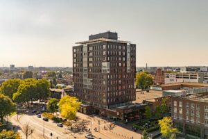 Luchtfoto van een appartementencomplex in het centrum van Enschede met uitzicht over de stad. Perfecte locatie voor wie een woning in Enschede wil kopen.