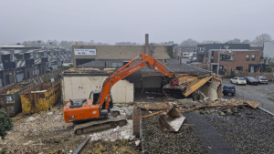 Start van de transformatie in Ede: een sloopkraan verwijdert het oude pand om ruimte te maken voor kantoorruimte en woningen met kantoor aan huis.