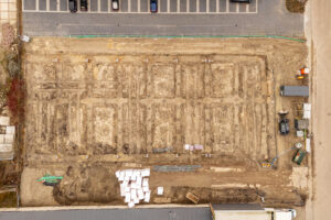 Top-down luchtfoto van het bouwterrein van fase II van bedrijfspand Oudenbosch, waarop de contouren van de toekomstige units duidelijk zichtbaar zijn.