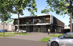 Gedetailleerde vooraanzicht van een bedrijfsruimte in Rotterdam met glazen pui, balkon en beplating in warme tinten, omringd door groen en bestrating.